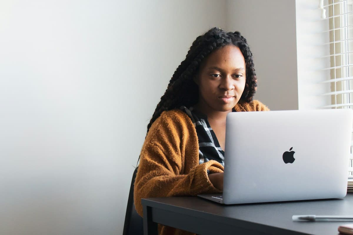 A business owner adding client details on her laptop