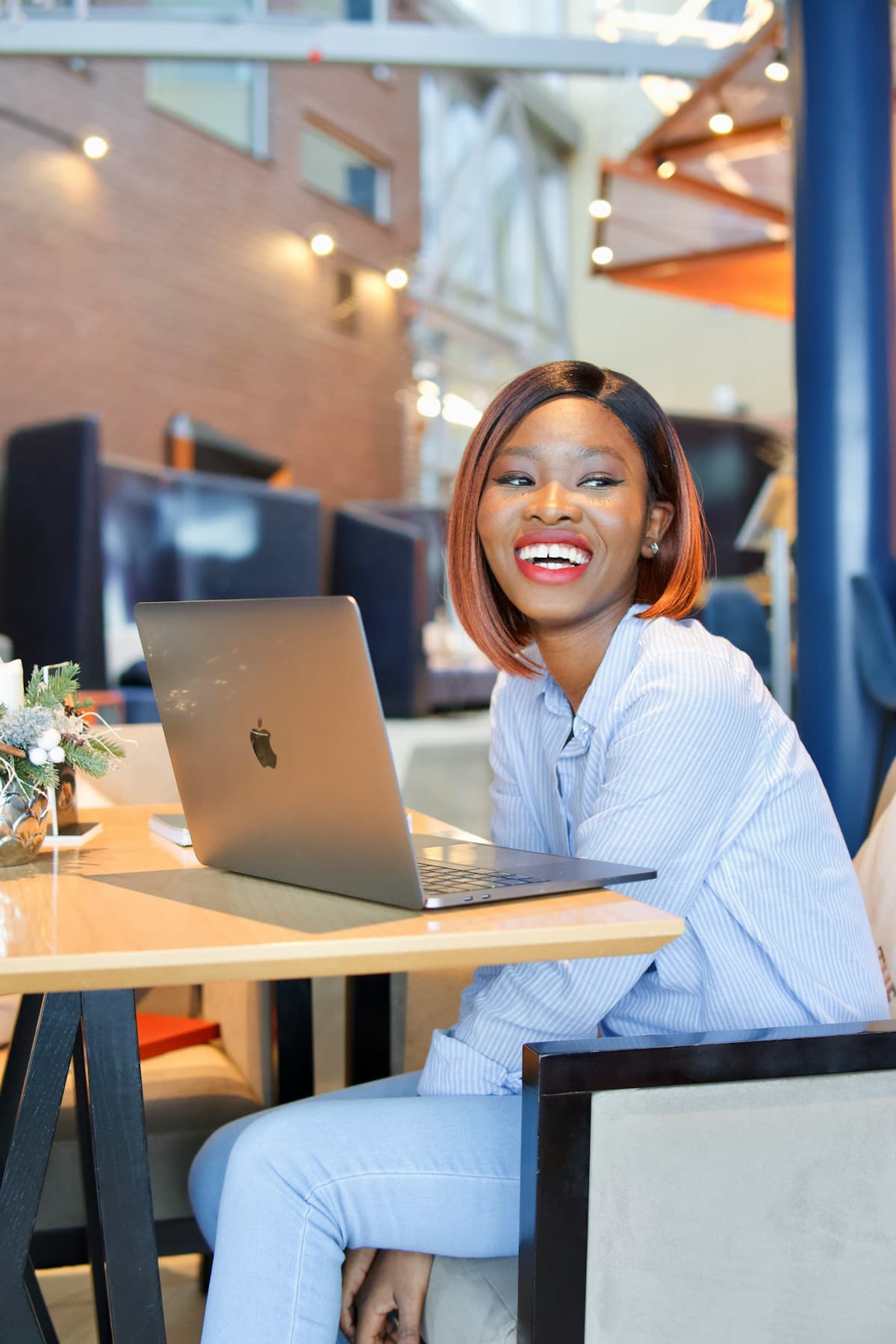 A smiling business owner sending an invoice from her laptop